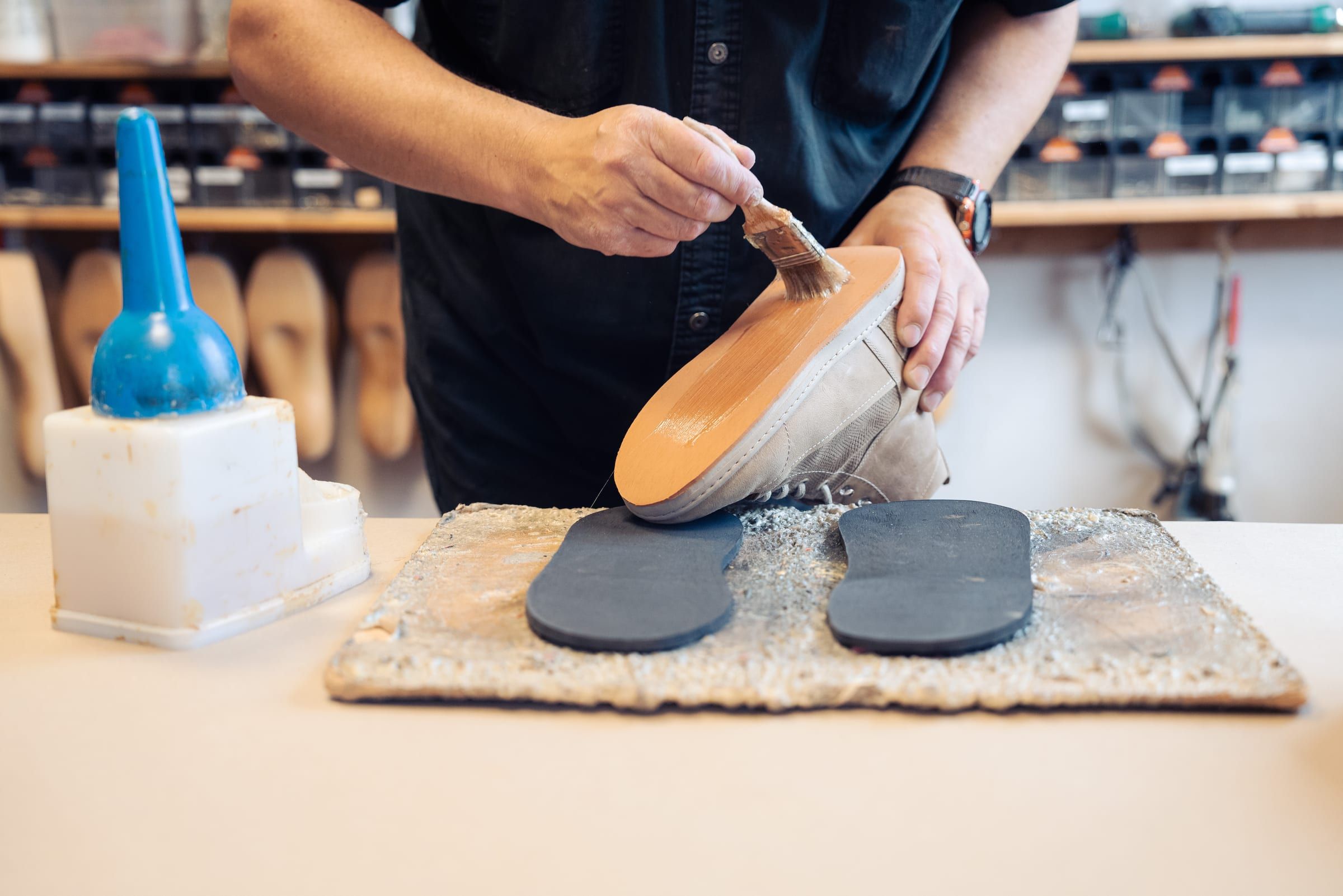 In der Werkstatt wird eine neue Sohle auf einen Schuh geklebt